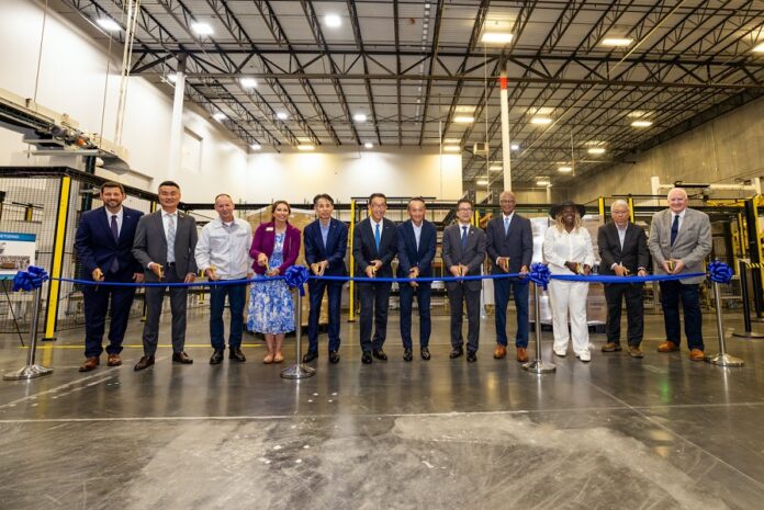 Attendees participate in a ribbon-cutting ceremony to celebrate the completion of the facility